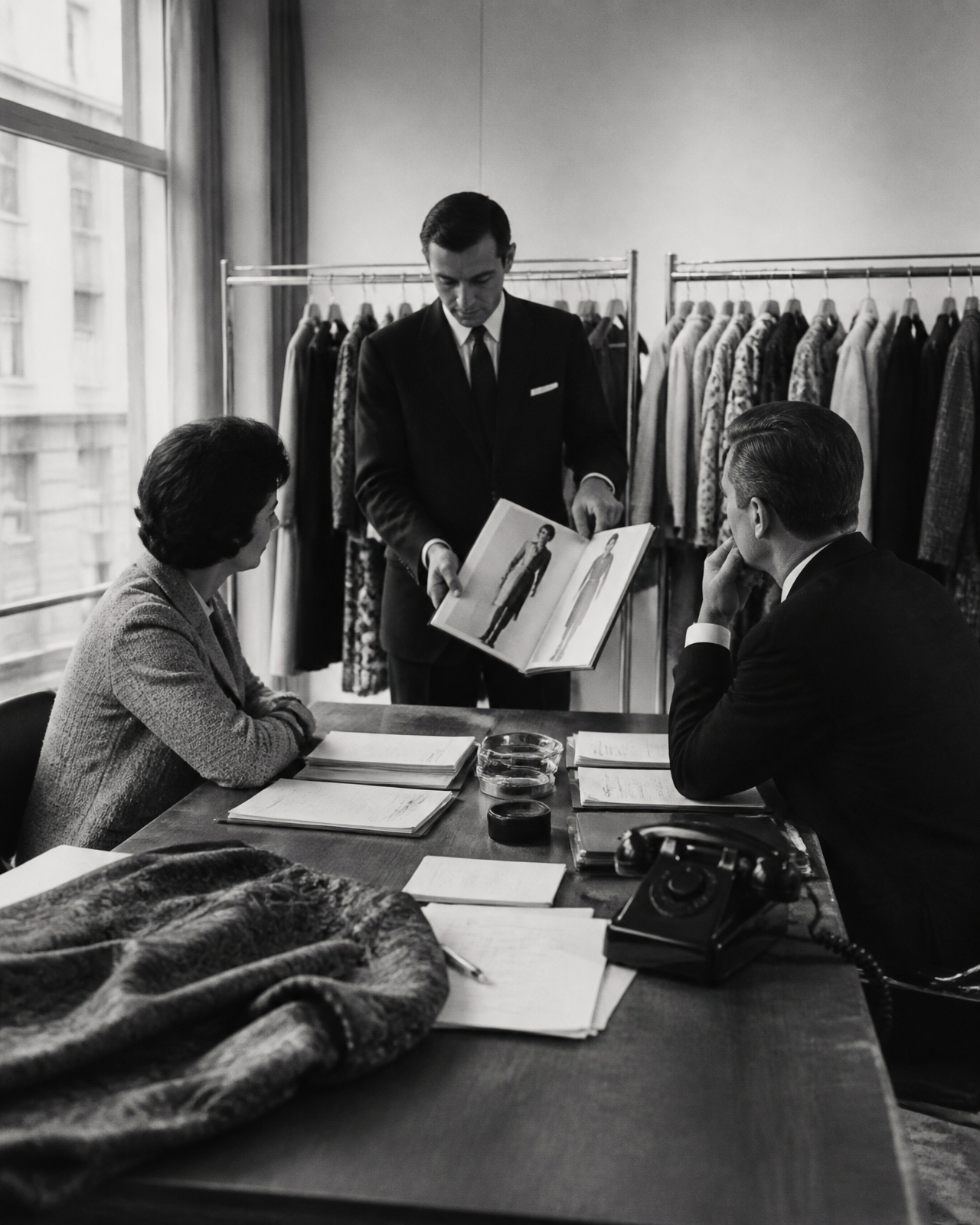 Reunión de compra en el showroom de una marca de moda, con panel de muestras de tejido y bocetos de colección